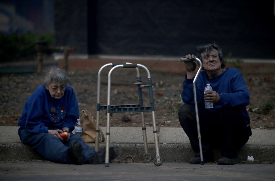 Juanita and Wayne McLish sit on a curb November 8 after losing their house to the Camp Fire in Paradise.