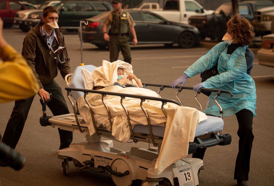 Patients are evacuated from Paradise's Feather River Hospital as it burns on Thursday, November 8.