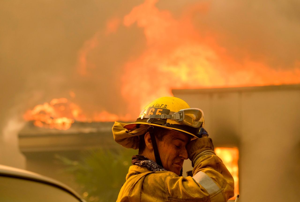 A firefighter keeps watch as the Woolsey Fire burns a home near Malibu Lake on November 9. 