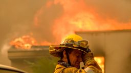 A firefighter keeps watch as a wildfire burns a home in Malibu, California. (AP Photo/Ringo H.W. Chiu)