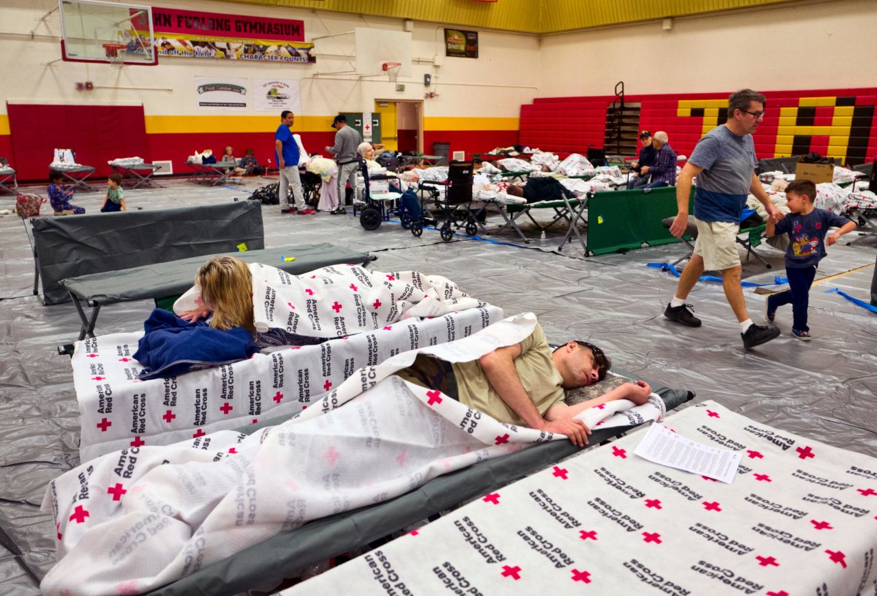 Evacuees rest on cots supplied by the Red Cross at a Los Angeles high-school gym on November 9.