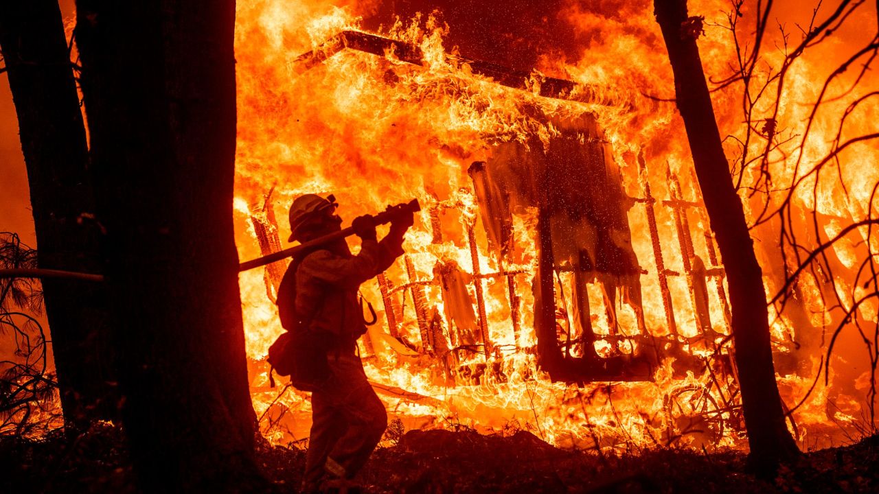 Firefighter Jose Corona sprays water as flames consume a house in Magalia, California.