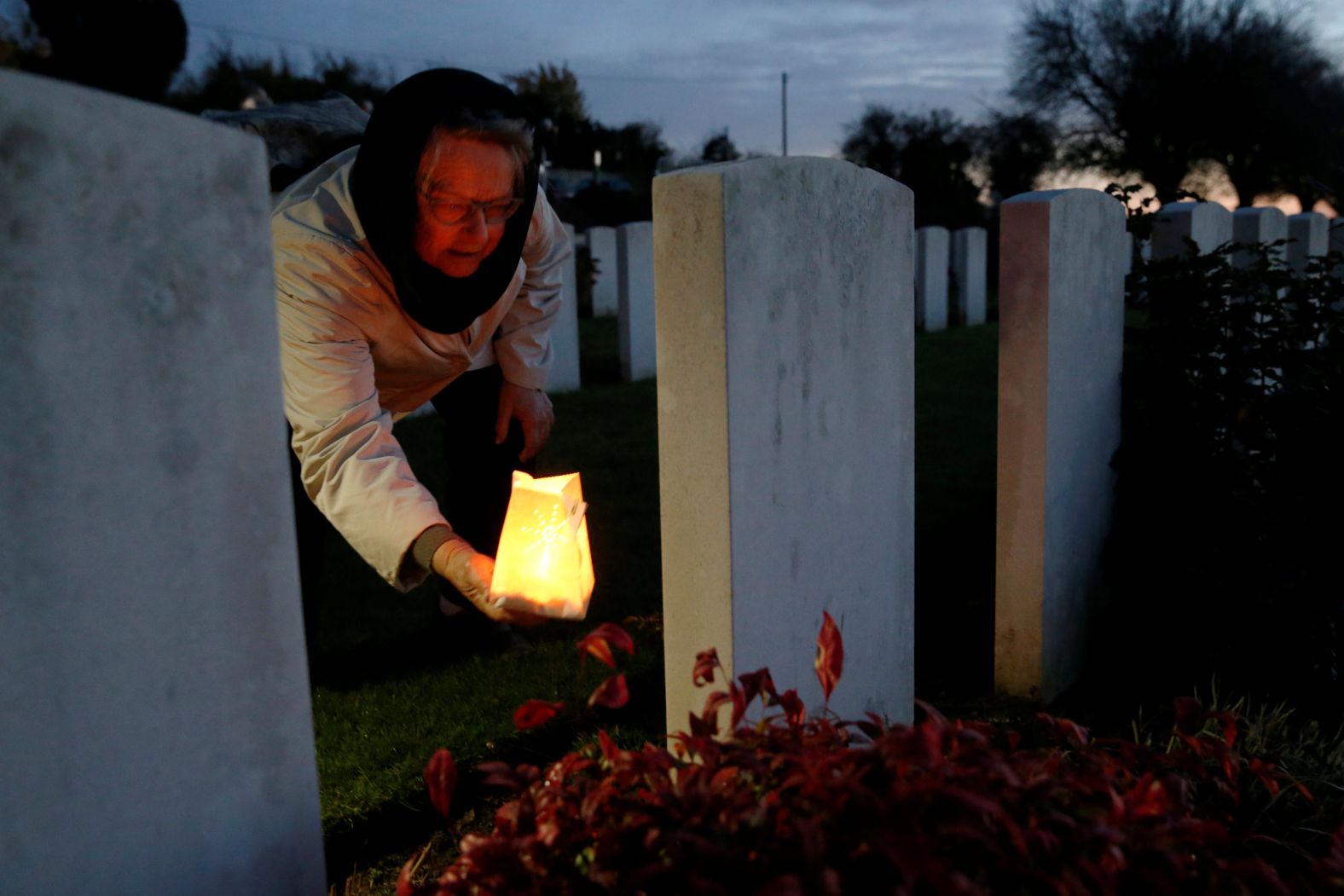 A woman places a candle at the grave of a soldier who died during World War I, at La Targette British Cemetery on November 10 in Neuville-Saint-Vaast, France.