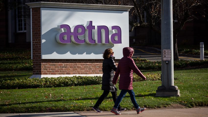 Pedestrians walk past signage Aetna Inc. headquarters in Hartford, Connecticut, U.S., on Tuesday, Nov. 22, 2016. The Justice Department sued to block the union of Aetna Inc. and Humana Inc., saying they would reduce the number of large, national health care insurance providers, leading to increased costs for their clients. Photographer: Michael Nagle/Bloomberg via Getty Images