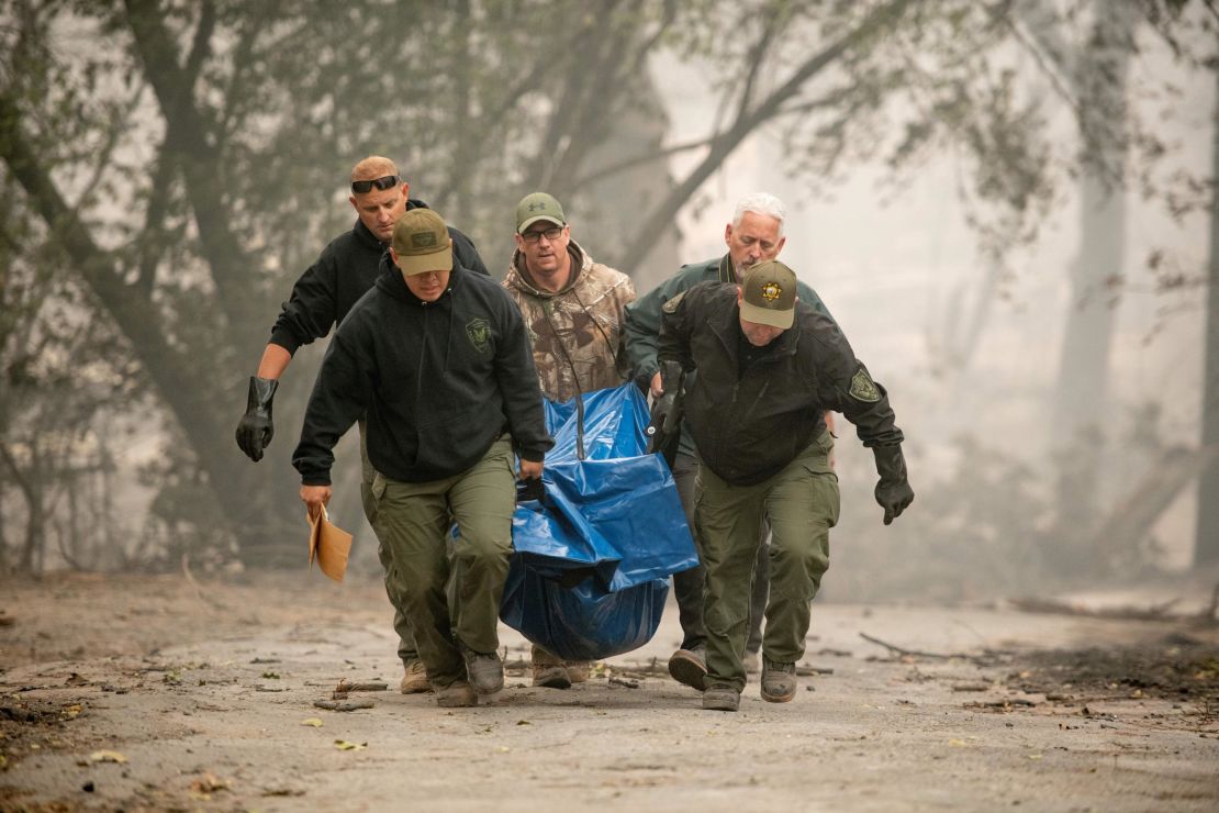 Yuba County Sheriff officers carry a body away from a burned residence in Paradise, California, on November 10, 2018.