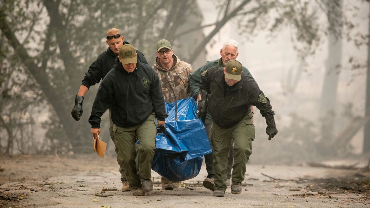 Yuba County Sheriff officers carry a body away from a burned residence in Paradise, California, on November 10, 2018.