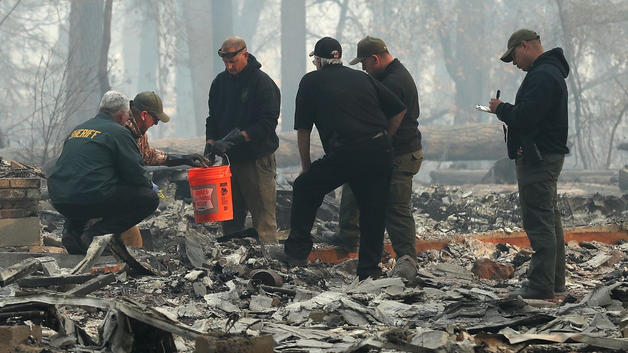 Yuba and Butte County sherriff's deputies sift through a destroyed home to collect the human remains of a victim of the Camp Fire on November 10 in Paradise.