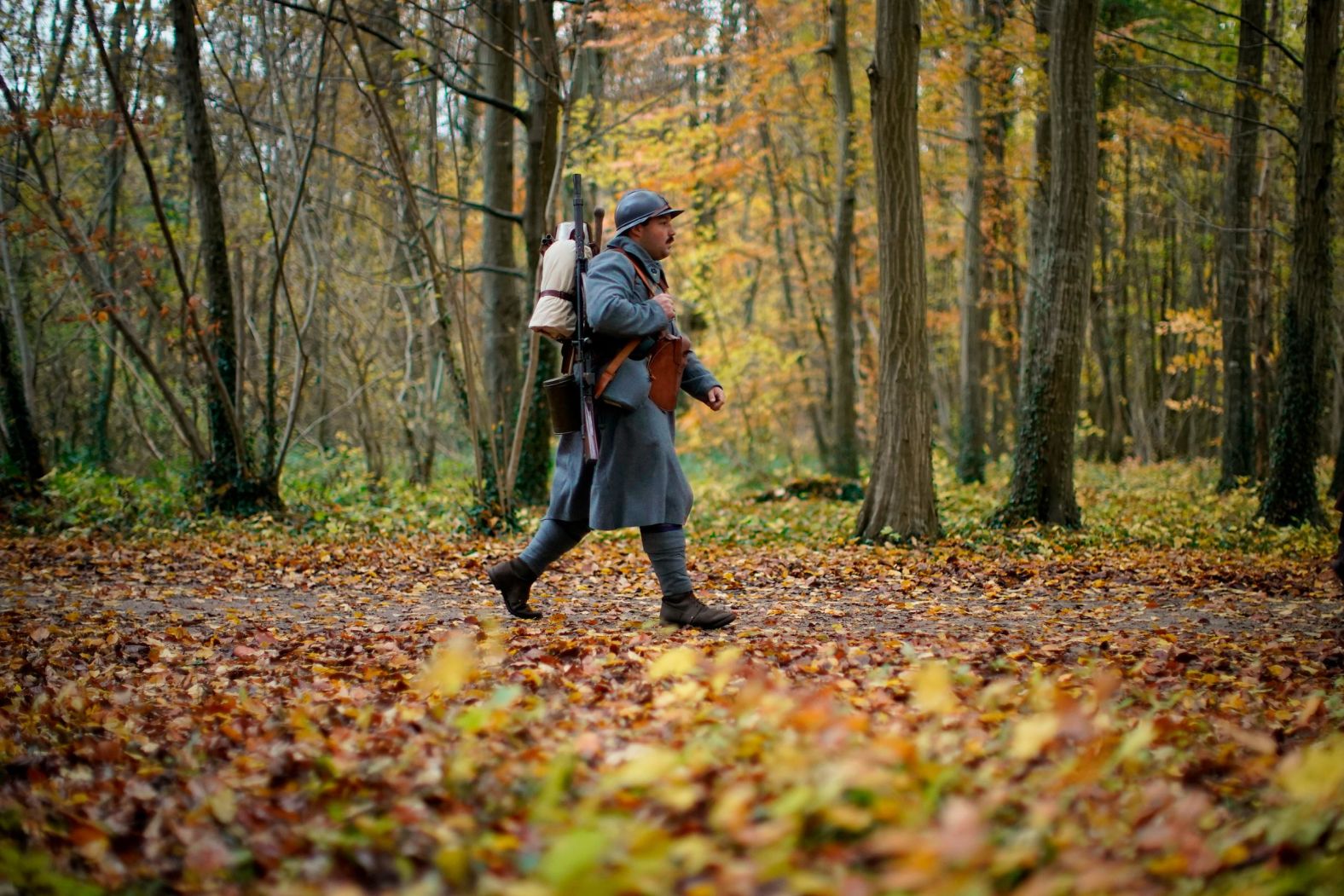 A historical re-enactor walks through the forest to the clearing of Rethondes to pay respects Sunday in Compiegne, France. The armistice ending the First World War between the Allies and Germany was signed at the clearing.