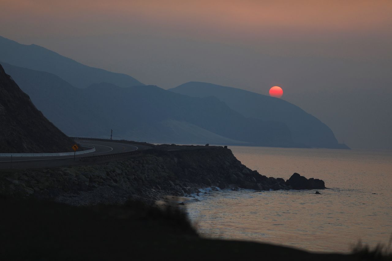 The sun rises over the Pacific Ocean on November 11 as the Woolsey Fire burns in Malibu.