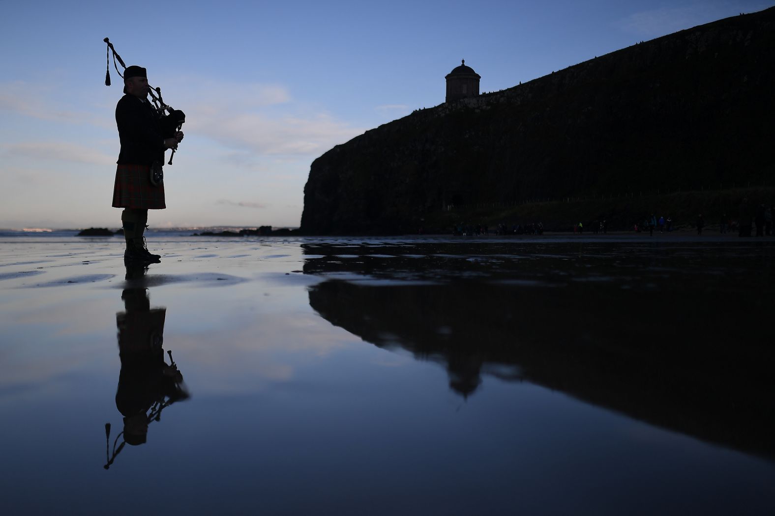 A bagpiper plays under Mussenden Temple on the beach in Coleraine, Northern Ireland on Sunday.