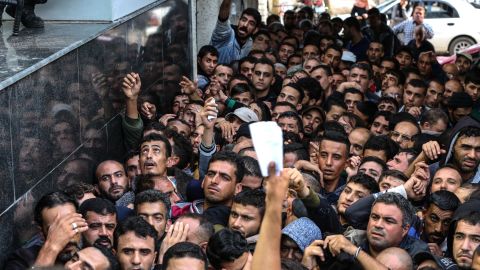 Palestinians gather to receive the cash that was brought into Gaza through Israel on Thursday by Qatar's envoy to Gaza.