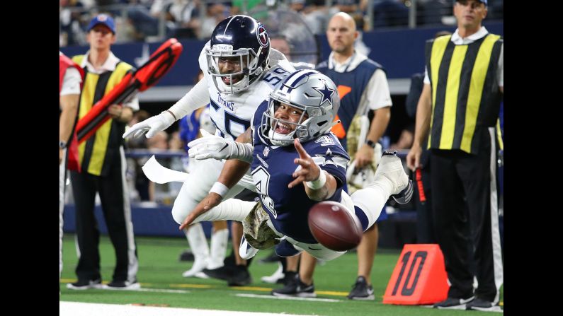 Dallas Cowboys quarterback Dak Prescott, defended by Tennessee Titans linebacker Wesley Woodyard, dives for a pass thrown by Cowboys wide receiver Cole Beasley in the fourth quarter at AT&T Stadium in Arlington, Texas on November 5. The Cowboys ultimately fell to the Titans 28-14.