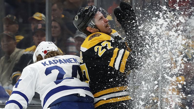 The Toronto Maple Leafs' Kasperi Kapanen checks John Moore of the Boston Bruins into the boards during the third period of their game on November 10 in Boston, Massachusetts. 