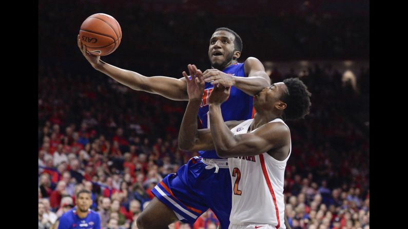 Houston Baptist Huskies guard Ian DuBose elbows Arizona Wildcats guard Brandon Williams while shooting the ball during the first half of a game in Tucson, Arizona.