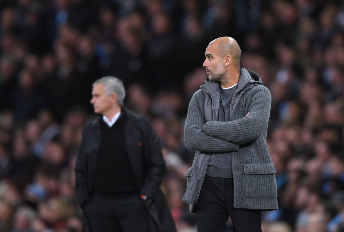 Man City's Pep Guardiola looks on in front of rival Jose Mourinho of Manchester United.
