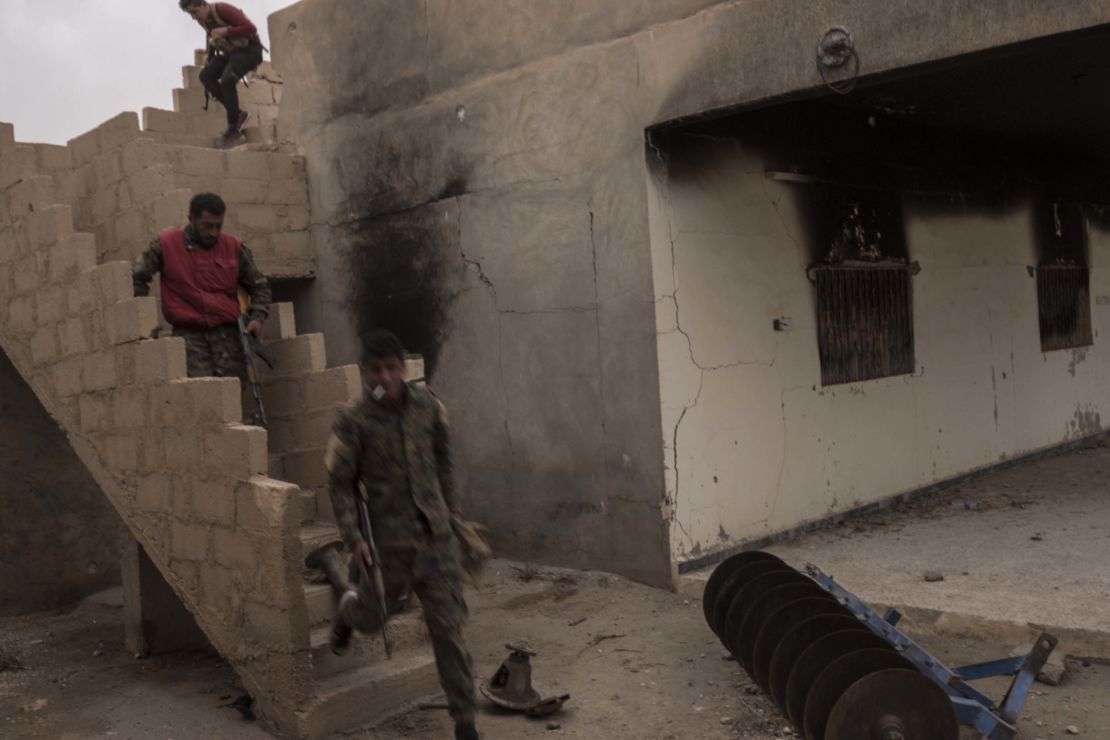 SDF fighters run to take cover during a counterattack by ISIS forces inside SDF lines on October 24 in Sousa, Syria.