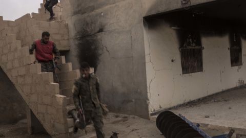 SDF fighters run to take cover during a counterattack by ISIS forces inside SDF lines on October 24 in Sousa, Syria.