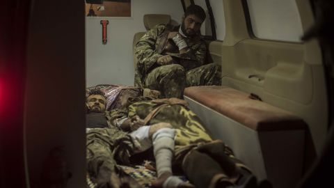 Two SDF soldiers await transfer to a hospital alongside the body of one their fallen comrades (bottom center) in an ambulance in Sousa, on October 25.