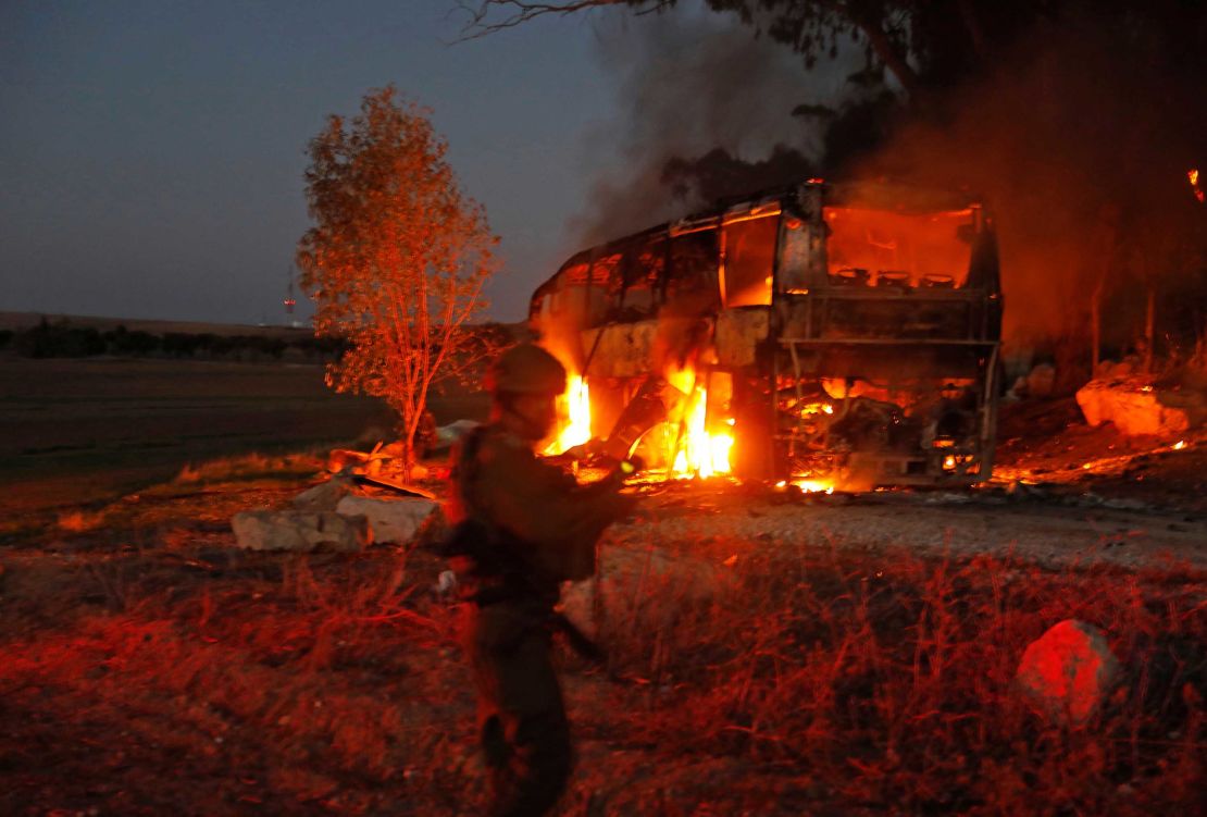 Israeli security forces and firefighters gather near a bus hit by a rocket fired from Gaza.
