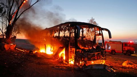 A bus set ablaze after it was hit by a rocket fired from the Gaza Strip, at the Israel-Gaza border near Kfar Aza.