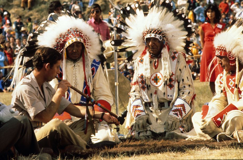 Charles smokes a peace pipe during a visit to Canada in July 1977.