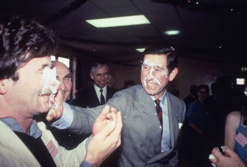Prince Charles shares a playful pie in the face while visiting a community center in Manchester, England, in December 1983.
