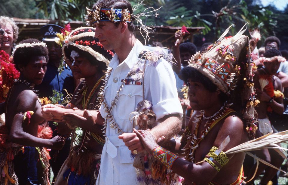 Charles walks with people in traditional dress on a visit to Papua New Guinea in 1984. 