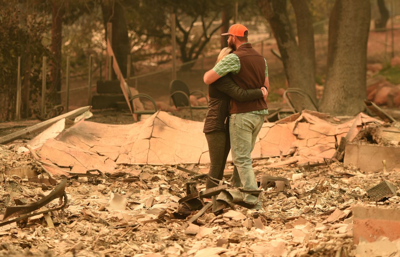 Chris and Nancy Brown embrace while looking over the remains of their home on November 12.
