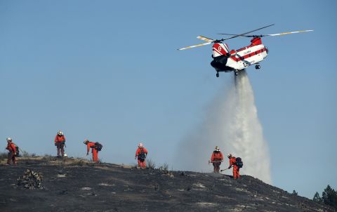 Firefighters put out hot spots in Thousand Oaks on November 12.
