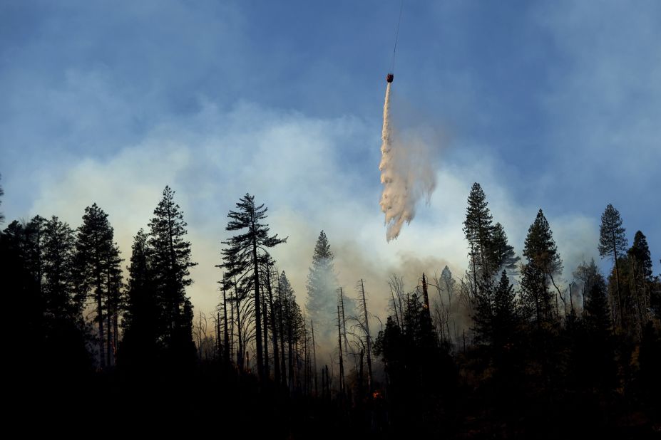 A helicopter drops water while battling the Camp Fire near Pulga on November 11.