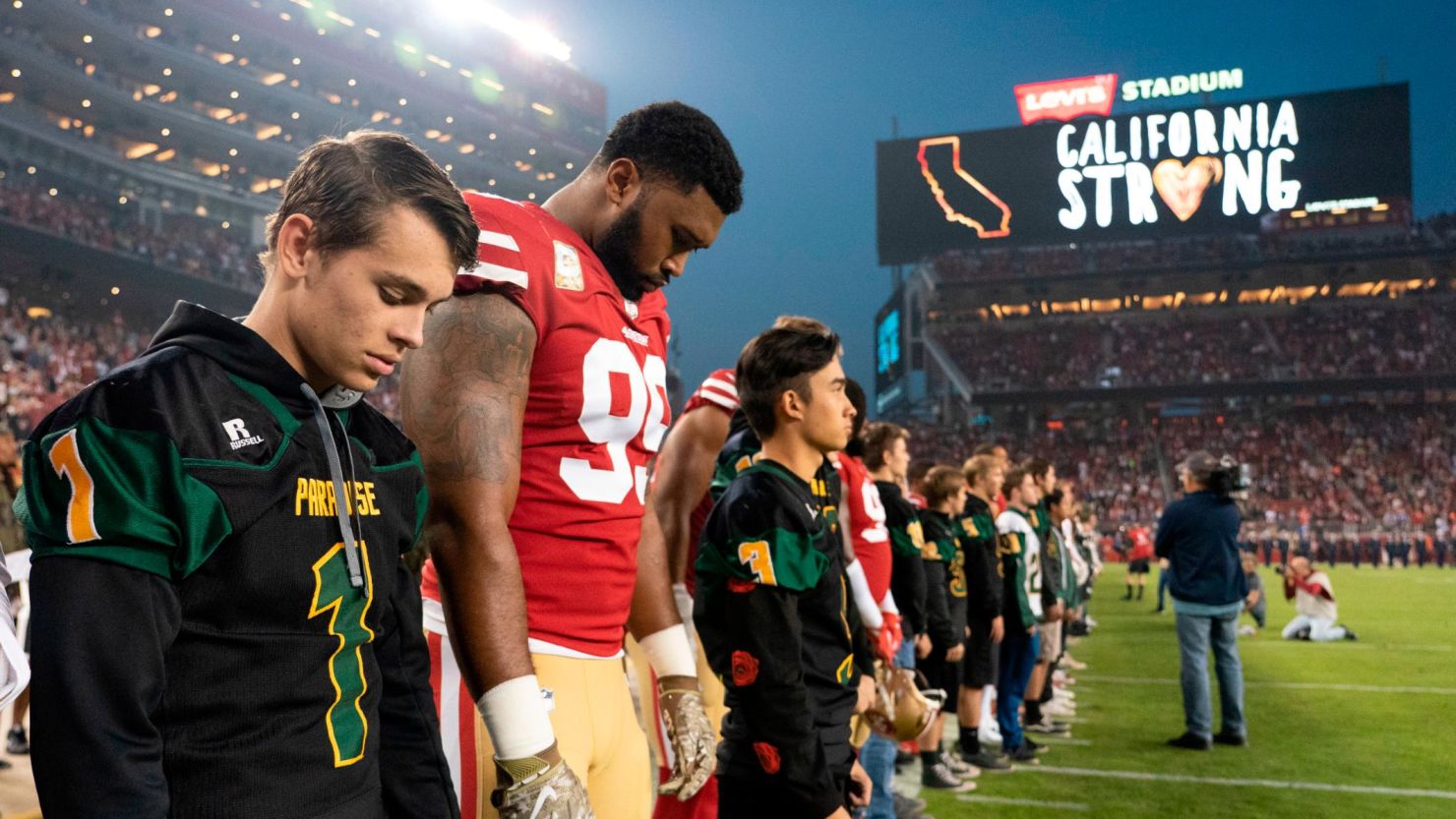San Francisco 49ers defensive tackle DeForest Buckner and Paradise High School football players observe a moment of silence before the game against the New York Giants.