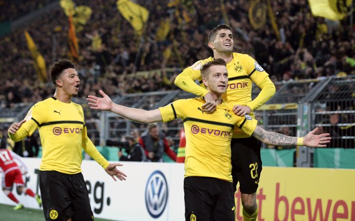 Marco Reus (center) celebrates with teammates Christian Pulisic and Jadon Sancho after scoring for Borussia Dortmund during the DFB Cup match against 1. FC Union Berlin at Signal Iduna Park on October 31, 2018.