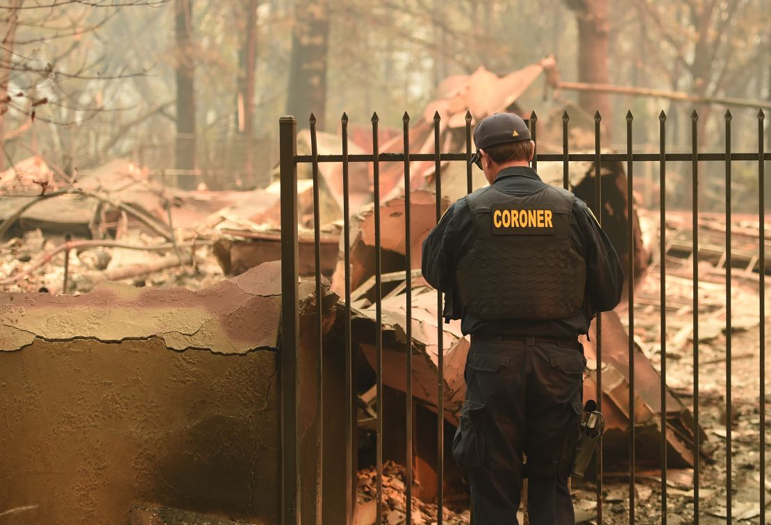 An Alameda County coroner looks for human remains at a burned home in Paradise, California.