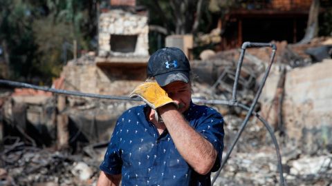 Roger Kelton, searches through the remains of his mother-in-law's home in Agoura Hills. 