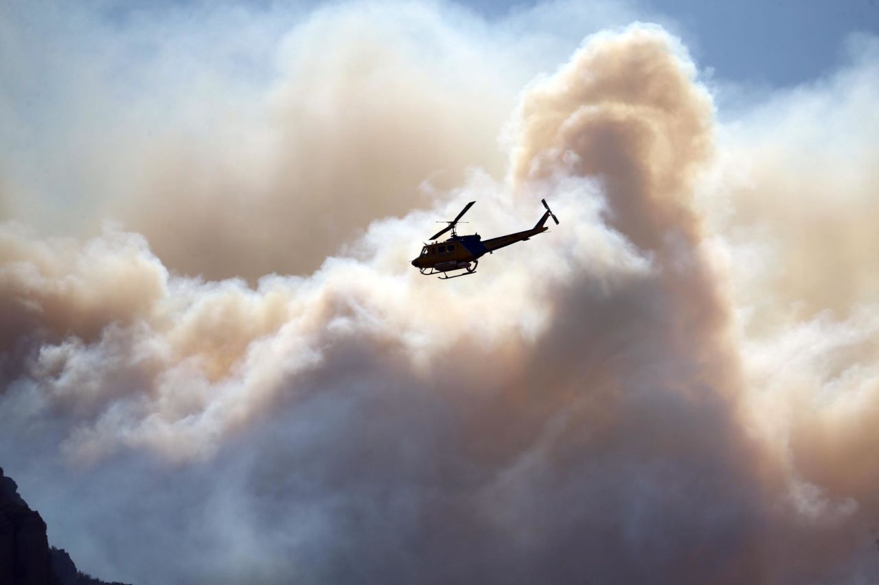 A helicopter flies near the Woolsey Fire burning in the Santa Monica Mountains National Recreation Area.