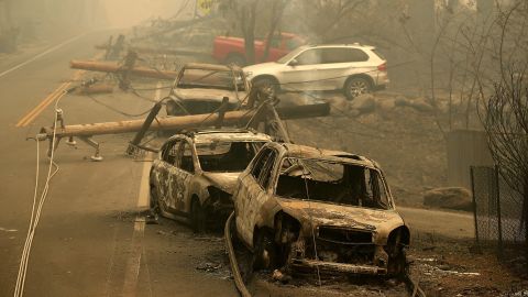 Power lines rest on cars that were burned by the Camp Fire on November 10, 2018 in Paradise, California.
