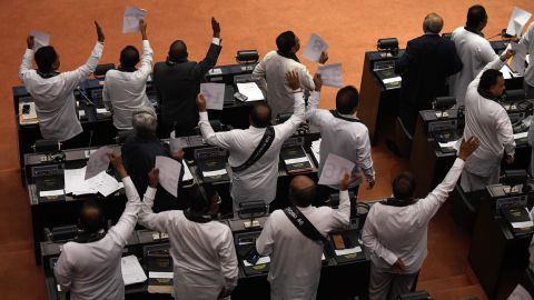 Lawmakers show their support for Sri Lanka's ousted prime minister Ranil Wickremesinghe during a parliamentary session in Colombo on November 14, 2018. 