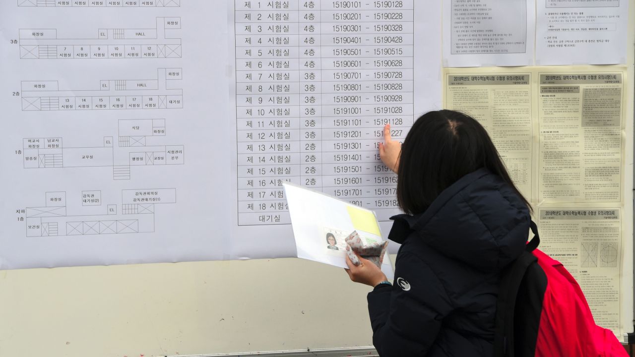 A student checks her exam room number before the annual College Scholastic Ability Test, a standardised exam for college entrance, at a high school in Seoul on November 23, 2017.