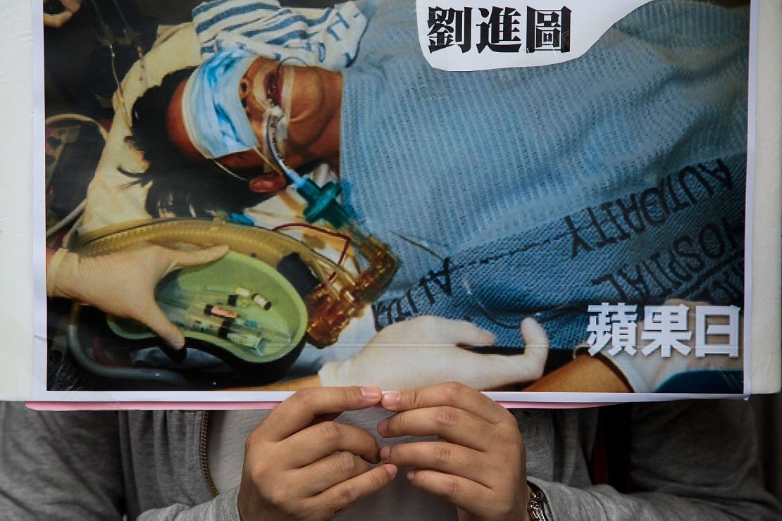A protester holds a sign showing Ming Pao editor Kevin Lau in hospital after he was attacked in 2014. 