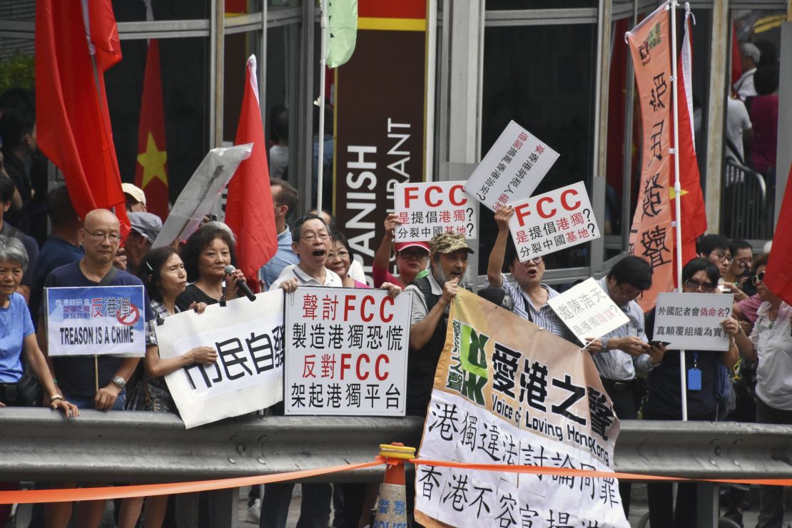 People raise pro-China signs in a protest against Hong Kong independence in front of the Foreign Correspondents' Club in Hong Kong on August 14, 2018. 