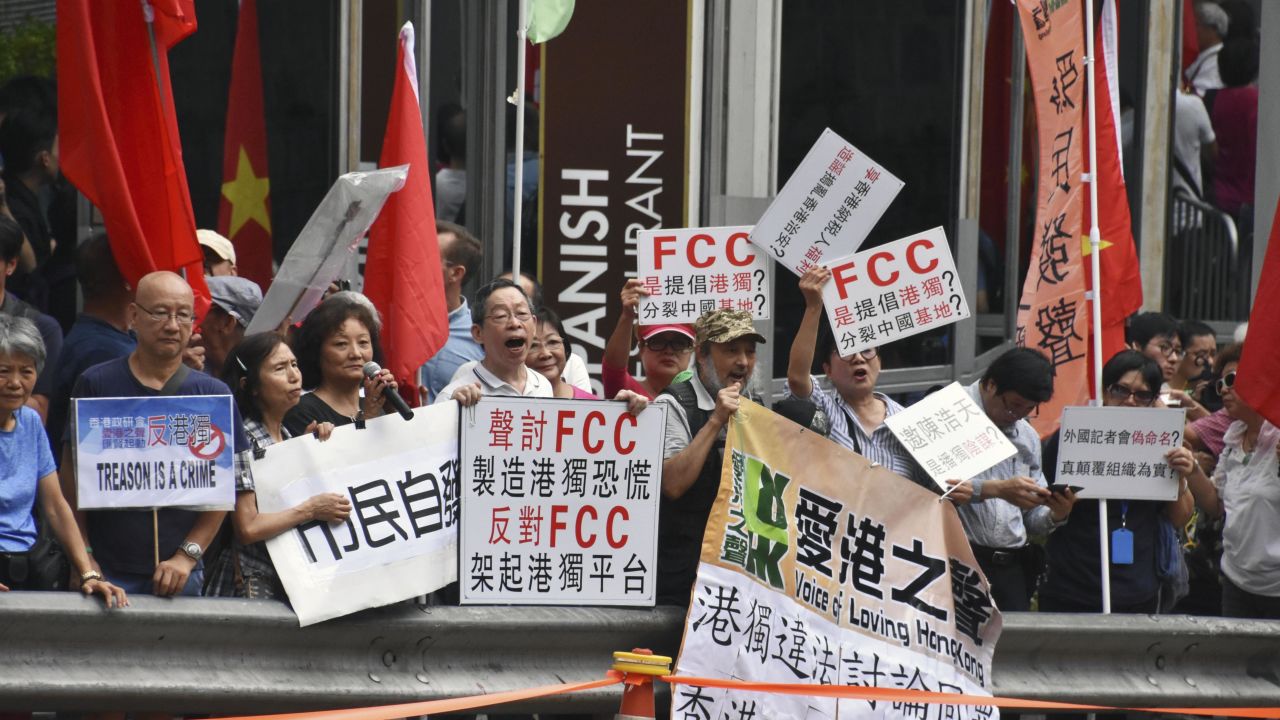 People raise pro-China signs in a protest against Hong Kong independence in front of the Foreign Correspondents' Club in Hong Kong on August 14, 2018. 