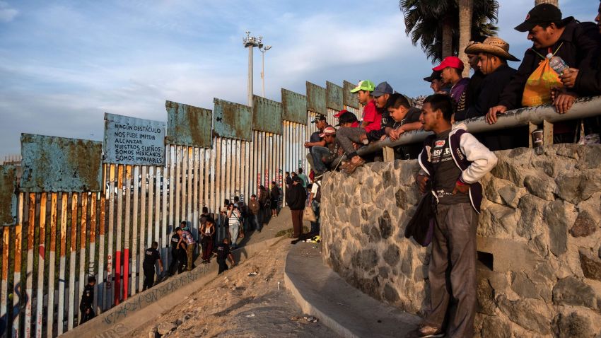Central American migrants -mostly Hondurans- moving towards the United States in hopes of a better life, are seen near the US-Mexico border fence with a sign that reads "No obstacle can prevent us from reaching our dreams. We are Mexican. We are unstoppable" in Playas de Tijuana, Mexico, on November 13, 2018. - US Defence Secretary Jim Mattis said Tuesday he will visit the US-Mexico border, where thousands of active-duty soldiers have been deployed to help border police prepare for the arrival of a "caravan" of migrants. (Photo by Guillermo Arias / AFP)        (Photo credit should read GUILLERMO ARIAS/AFP/Getty Images)