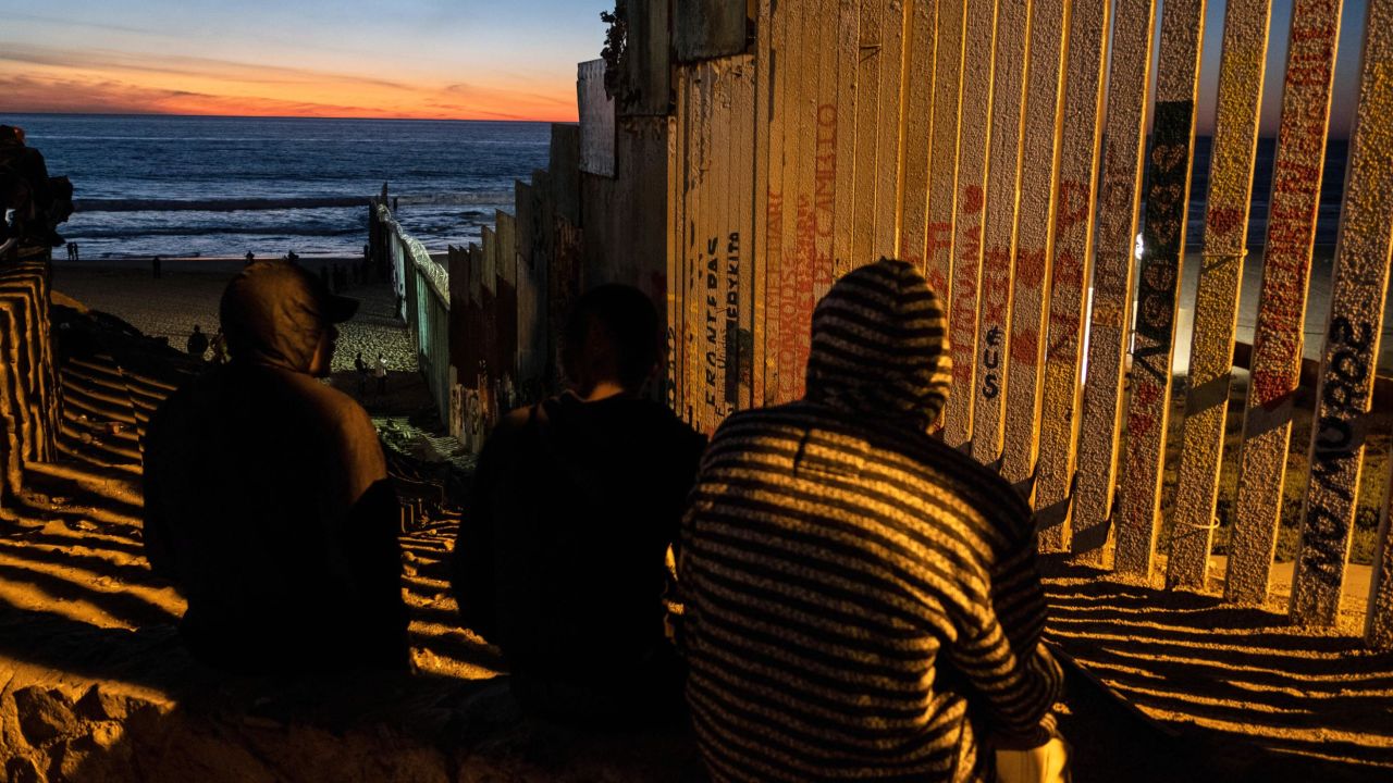 TOPSHOT - Central American migrants moving towards the United States in hopes of a better life, are seen near the US-Mexico border fence in Playas de Tijuana, Mexico, on November 14, 2018. - US Defence Secretary Jim Mattis said Tuesday he will visit the US-Mexico border, where thousands of active-duty soldiers have been deployed to help border police prepare for the arrival of a "caravan" of migrants. (Photo by Guillermo Arias / AFP)        (Photo credit should read GUILLERMO ARIAS/AFP/Getty Images)