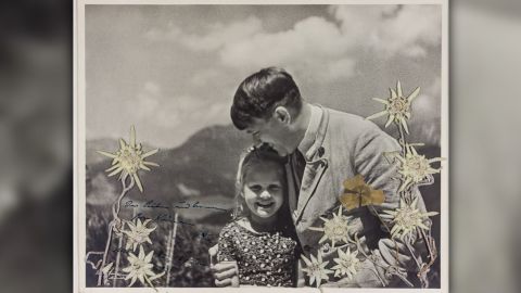 The photograph shows Hitler embracing Rosa Bernile Nienau, then about five or six, and is embellished with flowers which were placed by the young girl, Alexander Historical Auctions said. 