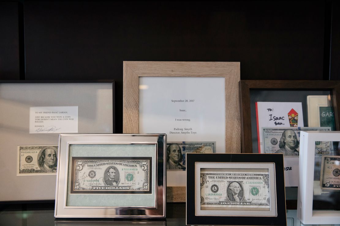 Framed $1, $5 and $100-dollar bills with notes declaring defeat from those who lost bets against Larian.