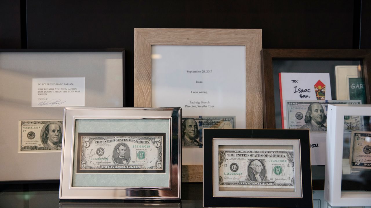 Framed $1, $5 and $100-dollar bills with notes declaring defeat from those who lost bets against Larian.