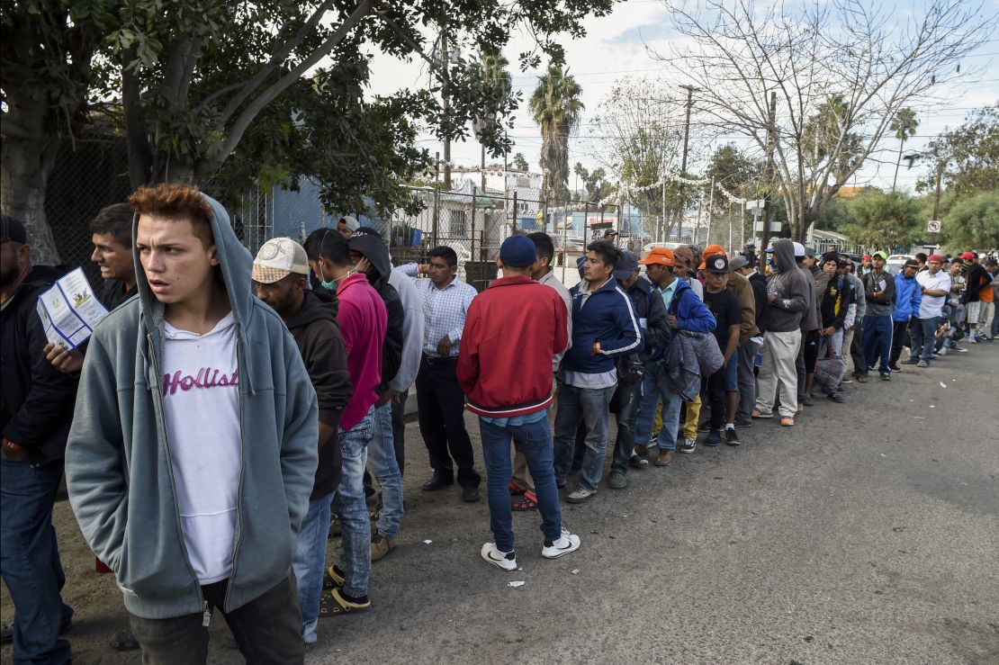 Central American migrants line up for food at a shelter in Playas de Tijuana on Friday.