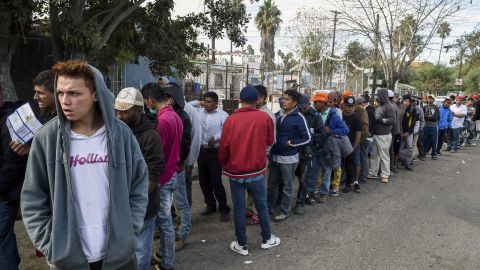Central American migrants line up for food at a shelter in Playas de Tijuana on Friday.