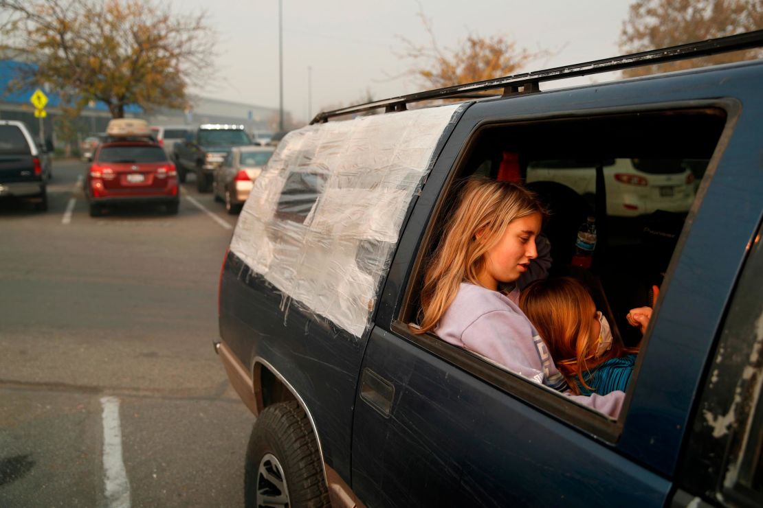 Dakota Keltner, right, rests on Havyn Cargill-Morris in a truck at the tent city outside a Walmart store in Chico.