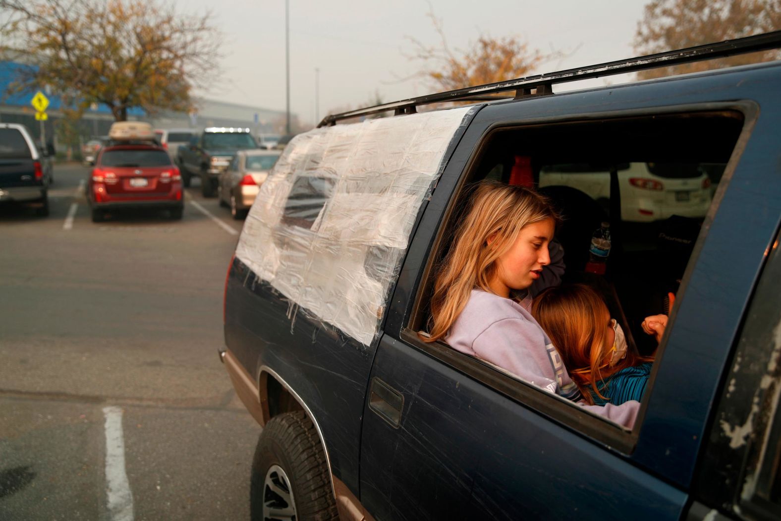 Dakota Keltner, right, rests on Havyn Cargill-Morris on November 16 in a truck at a makeshift encampment outside a Walmart store in Chico, California. The camp became a temporary respite for people displaced by the Camp Fire.